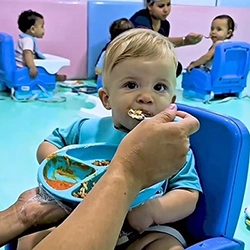 Bebê sendo alimentado na Escola Luz
